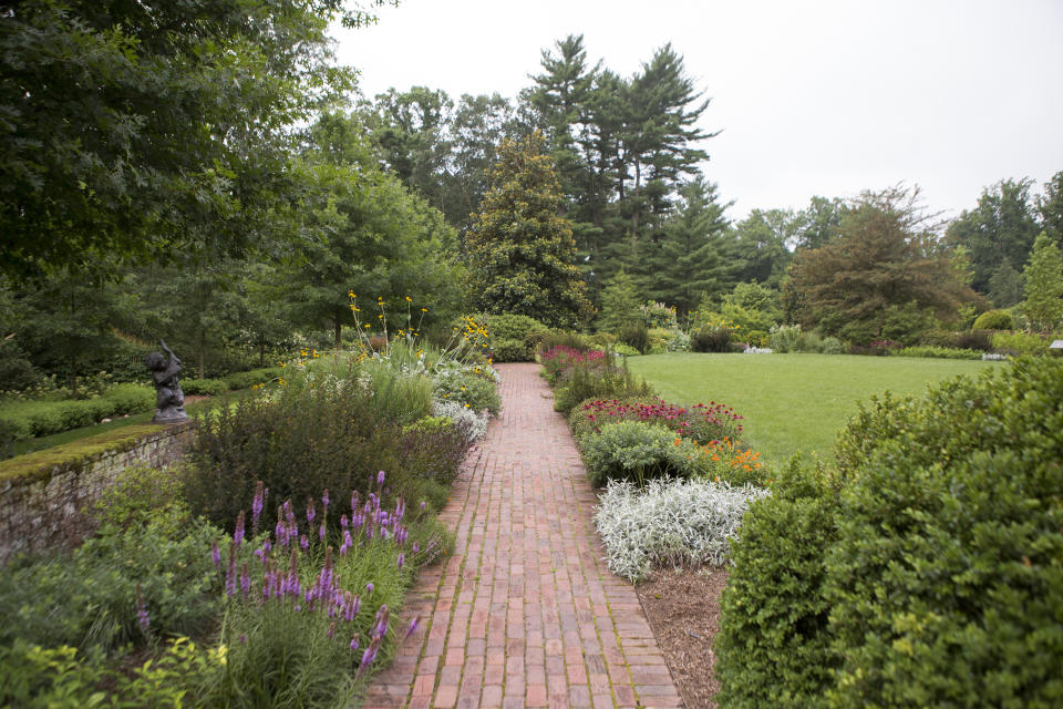 This undated photo provided by Mt. Cuba Center shows formal native plantings, including Asclepias tuberosa, Echinacea purpurea, Liatris, Physocarpus opulifolius and Artemesia ludoviciana, flanking a walkway at Mt. Cuba Center botanical garden in Hockessin, Del. (Alessandra Stokely/Mt. Cuba Center via AP)