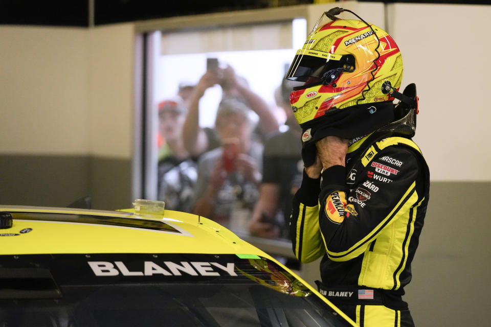 Ryan Blaney adjusts his helmet before getting into his car before a practice session for the NASCAR Daytona 500 auto race at Daytona International Speedway, Friday, Feb. 16, 2024, in Daytona Beach, Fla. (AP Photo/John Raoux)