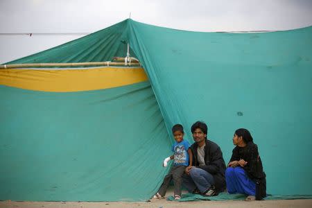 A child who was injured during an earthquake sits outside a makeshift shelter along with his family on open ground to keep safe in Kathmandu, Nepal April 26, 2015. REUTERS/Navesh Chitrakar