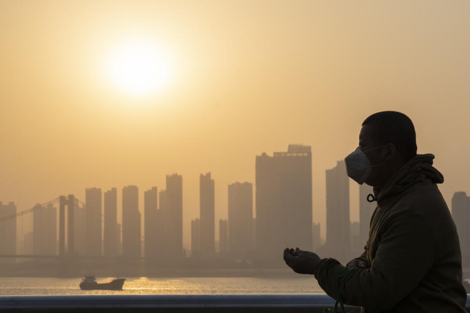 Un hombre con mascarilla disfruta del paisaje y del sol en Wuhan. (AP Photo/Ng Han Guan)