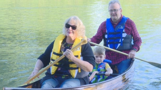 George Klassen, pictured here with his wife Cathy and two of his grandchildren, made a boat by recycling three pianos destined for the dump. (Janella Hamilton/CBC - image credit)