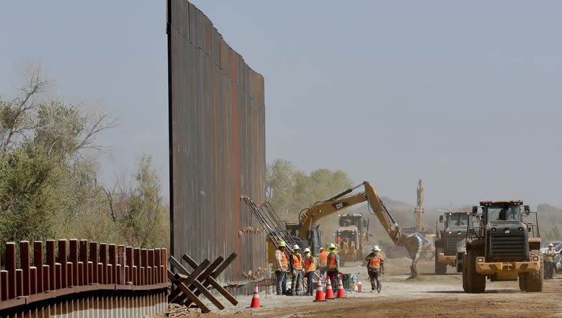 Government contractors erect a section of the Pentagon-funded border wall along the Colorado River, Sept. 10, 2019, in Yuma, Ariz. 