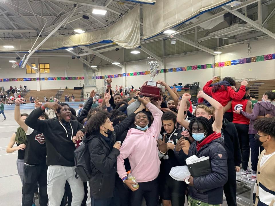 The Brockton High boys indoor track and field team celebrate after winning the Southeast Conference Championship Meet title on Wednesday, Feb. 9, 2022.