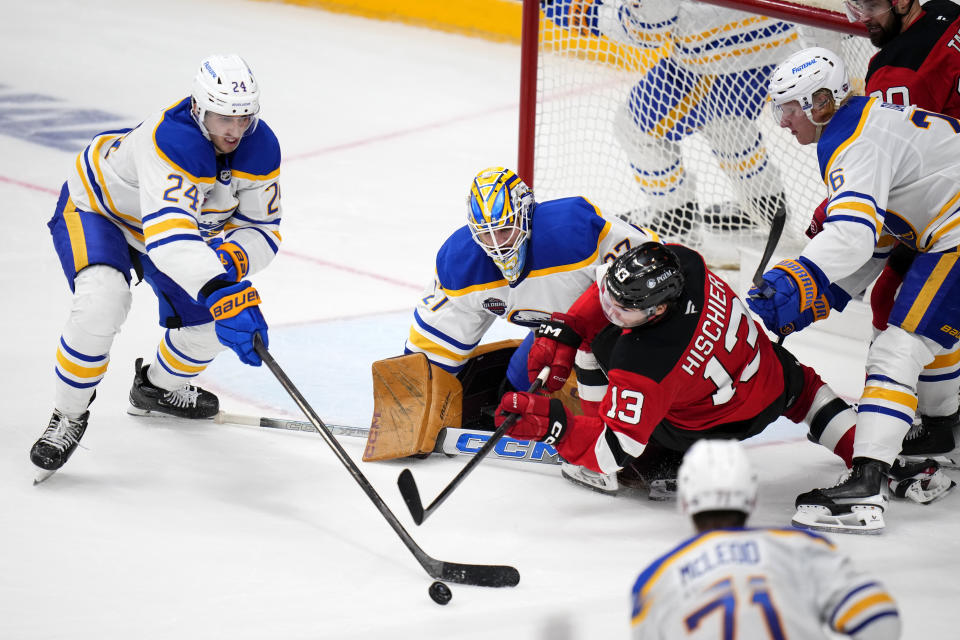 Buffalo Sabres' Dylan Cozen, left, challenges New Jersey Devils' Nico Hischier, 2nd right, during the NHL hockey game between Buffalo Sabres and New Jersey Devils, in Prague, Czech Republic, Saturday, Oct. 5, 2024. (AP Photo/Petr David Josek)