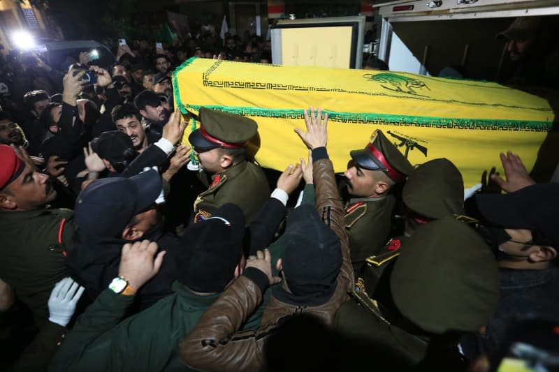 Members of the Popular Mobilization Forces (Hashed al-Shaabi), a powerful pro-Iranian militia, carry the bodies of two of their killed members during their funeral at the PMF headquarters. The two members of the militia, including a commander, were killed in an alleged US airstrike. Ameer Al-Mohammedawi/dpa