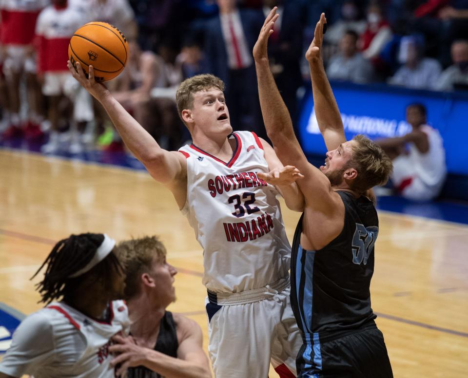 Southern Indiana's Jacob Polakovich (32) attempts a layup over Oakland City's Nathaniel Schmittler (50) during the basketball game between the University of Southern Indiana Screaming Eagles and the Oakland City University Mighty Oaks in Evansville, Ind., Thursday evening, Nov. 18, 2021.