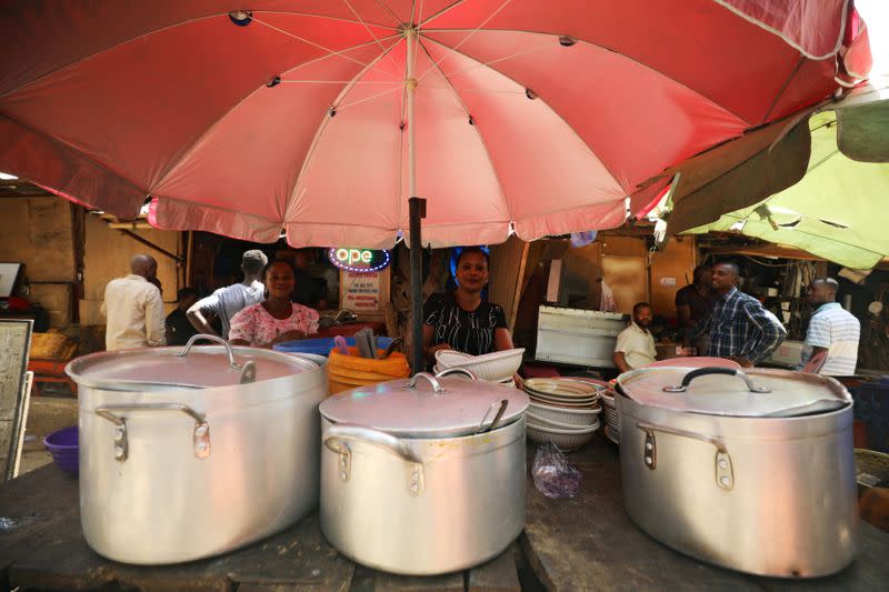 A food vendor arranges her sets of pots and plates on a table in Abuja