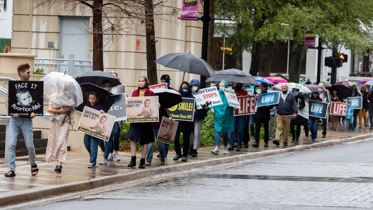 Despite the weather and the pandemic, attendees march along Hogan Street as they protest abortion. Jacksonville For Life hosted their annual March For Life as more than 120 attendees marched around the Bryan Simpson United States Courthouse on Hogan Street in downtown Jacksonville on Friday afternoon to protest abortion and the U. S. Supreme Court's Roe v. Wade decision. (Fran Ruchalski/for The Times-Union]
