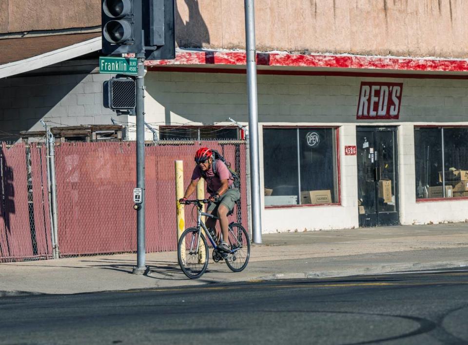 A bicyclist rides on the sidewalk along Franklin Blvd. on earlier this month. The Franklin Boulevard Complete Street project, set to begin construction in 2024, plans to add protected bike lanes, wider sidewalks, better street lighting and more shade trees to the central corridor of North City Farms neighborhood in Sacramento.