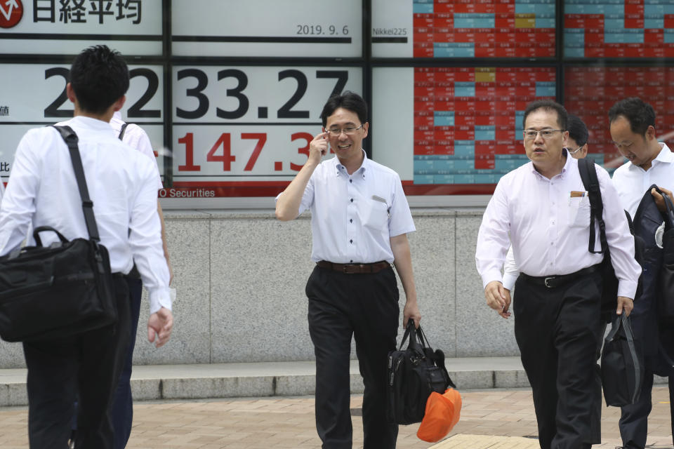 People walk by an electronic stock board of a securities firm in Tokyo, Friday, Sept. 6, 2019. Asian shares rose Friday as investors cheered plans for more trade negotiations between Washington and Beijing and drew encouragement from positive data about the U.S. economy. (AP Photo/Koji Sasahara)