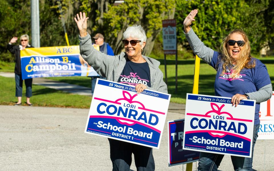 Lori Conrad, right, and her mother-in-law Jean Conrad, left, wave to motorists during the 2020 election.