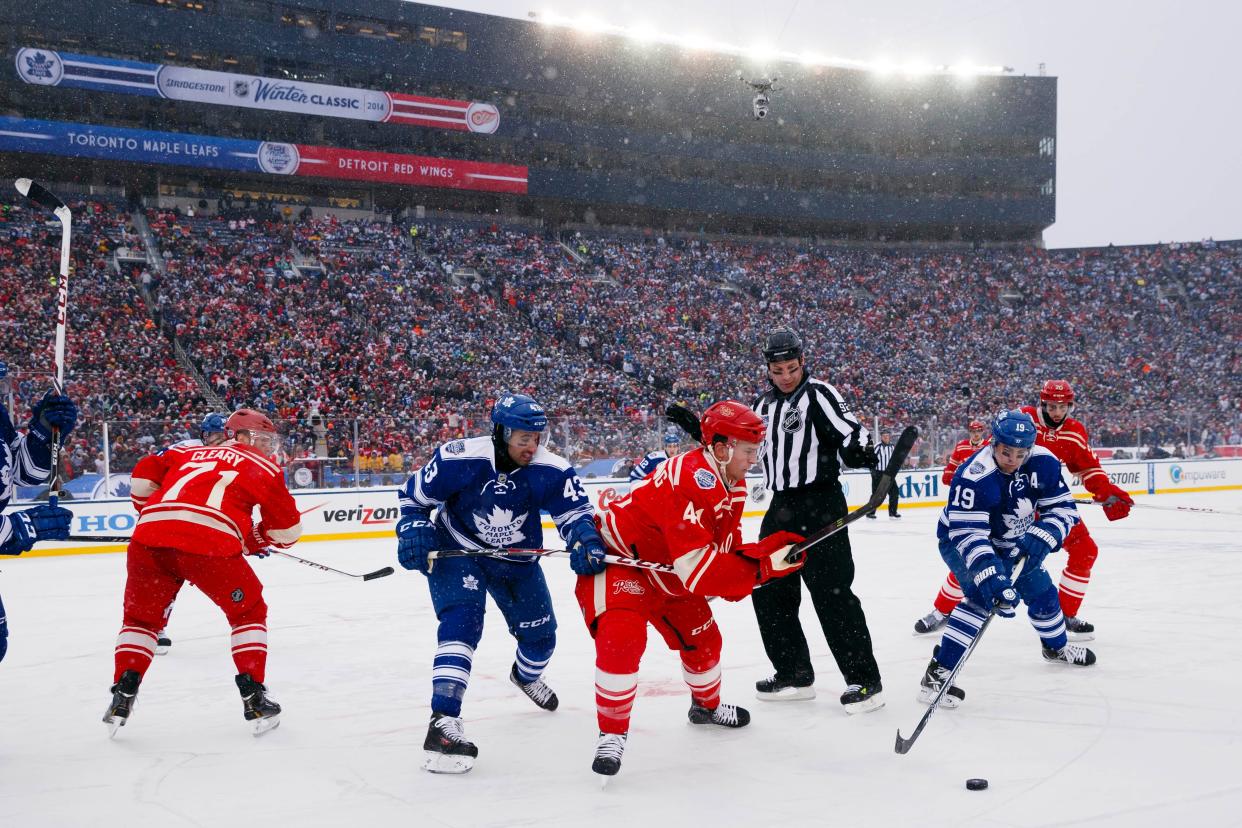 Jan 1, 2014; Ann Arbor, MI, USA; Detroit Red Wings right wing Luke Glendening (41) and Toronto Maple Leafs right wing Joffrey Lupul (19) battle for the puck during the 2014 Winter Classic hockey game at Michigan Stadium. Mandatory Credit: Rick Osentoski-USA TODAY Sports