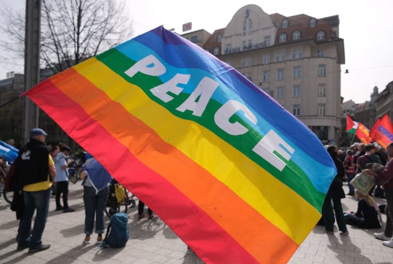 A colorful flag with the word "Peace" is held at a rally, as part of an Easter march with the slogan "Leipzig wants peace". Sebastian Willnow/dpa