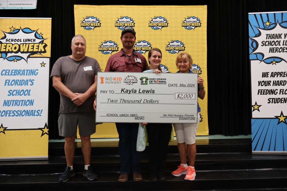 Kayla Lewis, of Englewood Elementary, center, with her family and a $2,000 check she received after being named a 2024 Florida School Lunch Hero, one of five in the state.