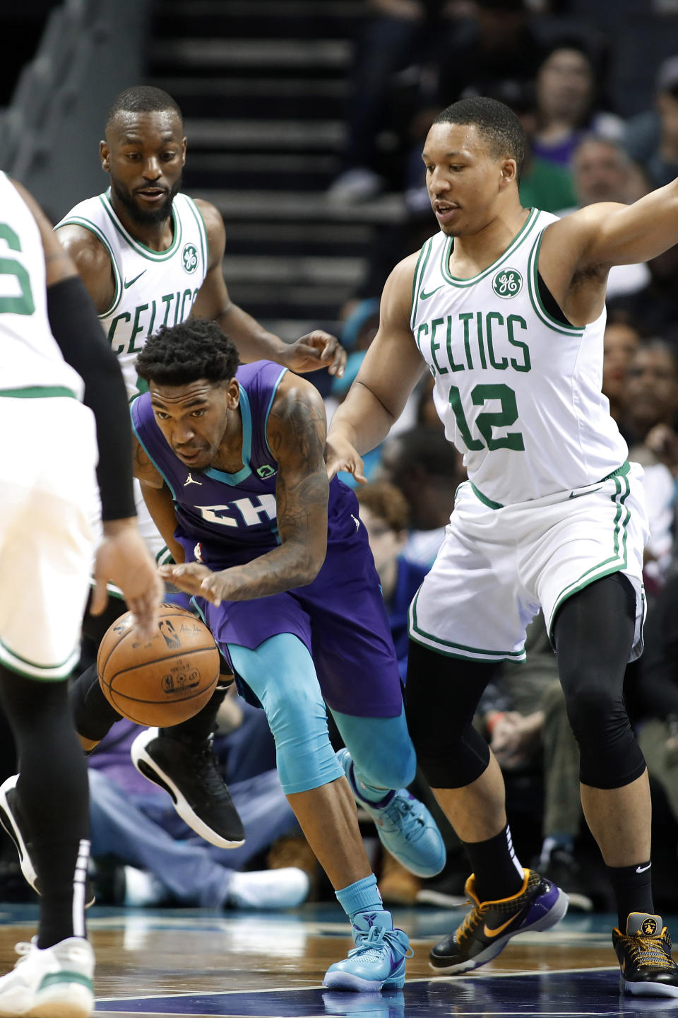 Charlotte Hornets' Malik Monk (1) dribbles away from Boston Celtics' Kemba Walker, left and Grant Williams, right, during the first half of an NBA basketball game in Charlotte, N.C., Thursday, Nov. 7, 2019. (AP Photo/Bob Leverone)