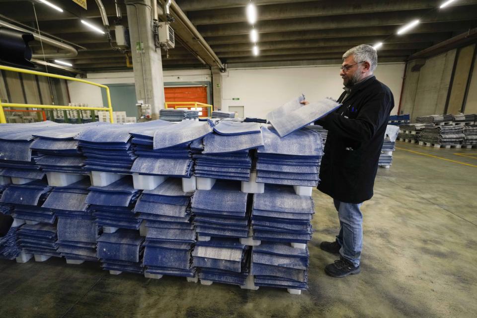 A worker fixes portion of the rubbery surface of the athletics track at the Mondo factory, in Alba, northern Italy, Wednesday, March 13, 2024. The athletics track for the upcoming Paris Olympics is being produced by the Mondo company at its factory in northern Italy. The track is made in portions, rolled up and then will be transported to the Stade de France, where it will be installed over the next month. (AP Photo/Luca Bruno)