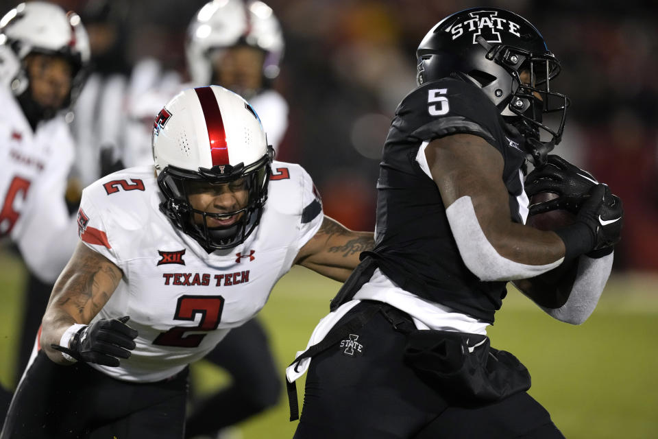 Iowa State running back Cartevious Norton (5) runs from Texas Tech defensive back Reggie Pearson Jr. (2) during the first half of an NCAA college football game, Saturday, Nov. 19, 2022, in Ames, Iowa. (AP Photo/Charlie Neibergall)