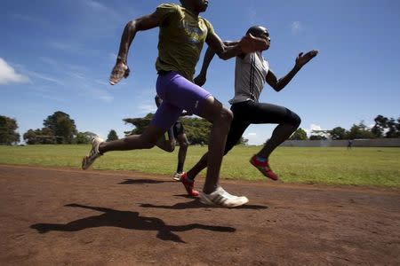 Athletes sprint during a training session on a dirt track in the town of Iten in western Kenya, November 13, 2015. Picture taken November 13, 2015. REUTERS/Siegfried Modola