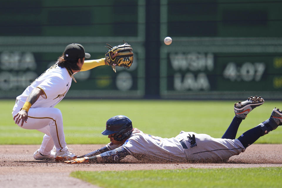 Houston Astros' Mauricio Dubon, right, slides safely into second with a double as Pittsburgh Pirates shortstop Ji Hwan Bae waits for the late throw during the first inning of a baseball game in Pittsburgh, Wednesday, April 12, 2023. (AP Photo/Gene J. Puskar)
