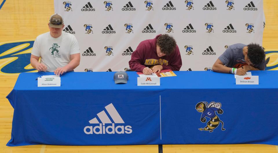 Alton Robinson, Missouri State, Cade McConnell, Minnesota, and DeSean Brown, OSU at Choctaw High School, signing letters of intent on national signing day, Wednesday, December 15, 2021. 