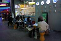 Customers sit at a tea drink store at a shopping complex in Beijing