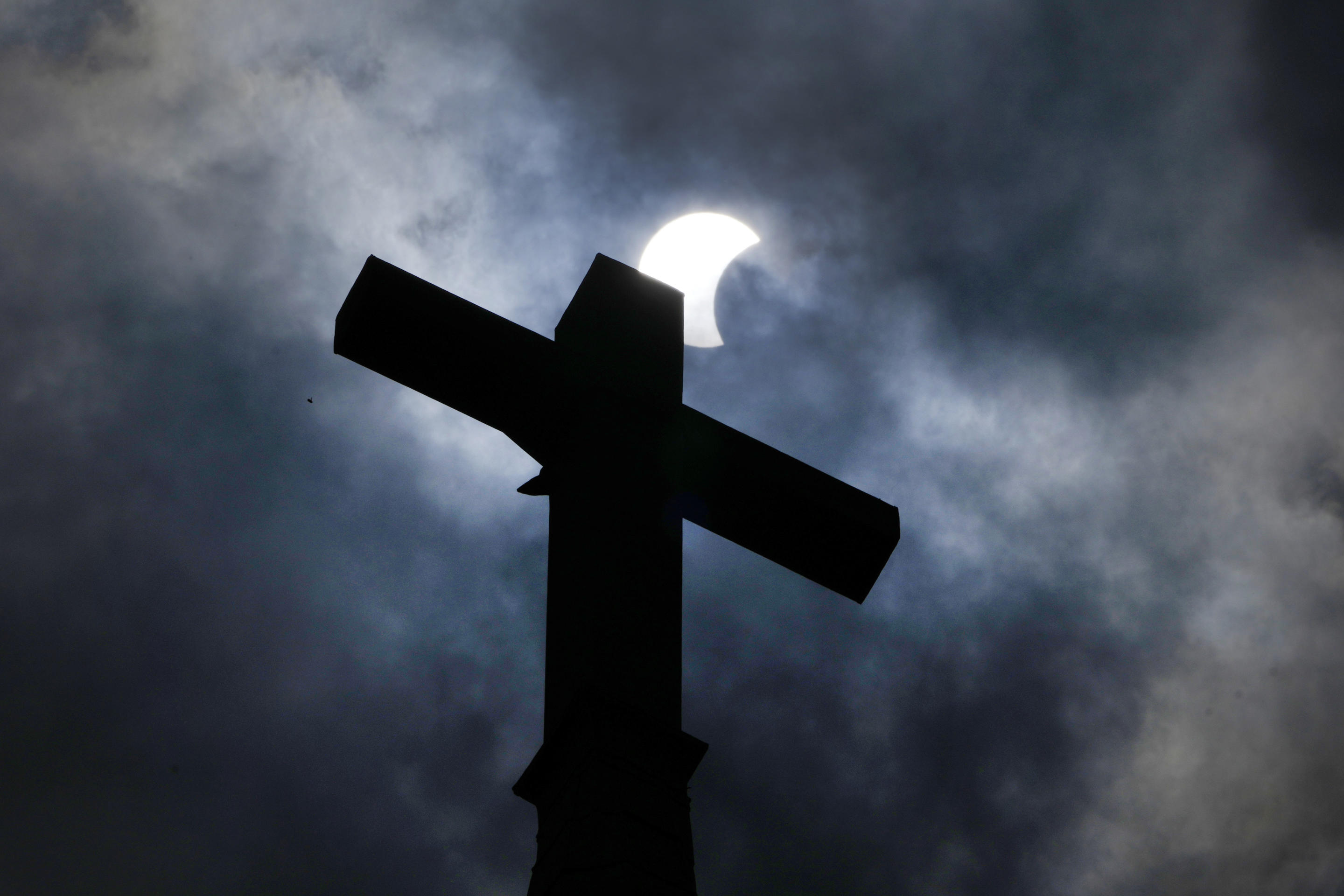 Clouds part as a partial eclipse of the sun and moon cross atop the New Sweden Evangelical Lutheran Church steeple Monday, April 8, 2024, in Manor, Texas. \