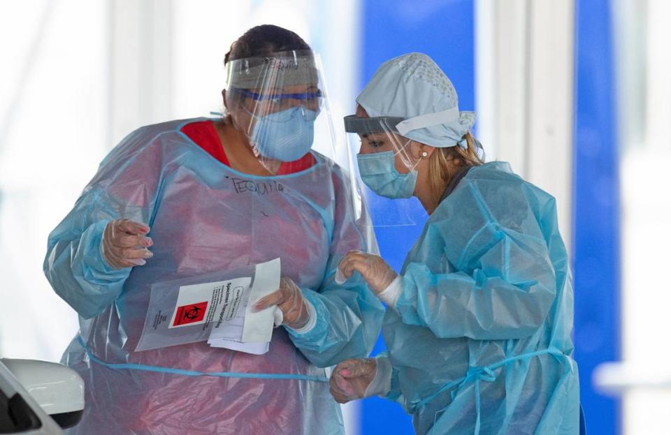 Healthcare workers talk at the COVID-19 drive-thru testing center at Miami-Dade County Auditorium in Miami on July 23, 2020.