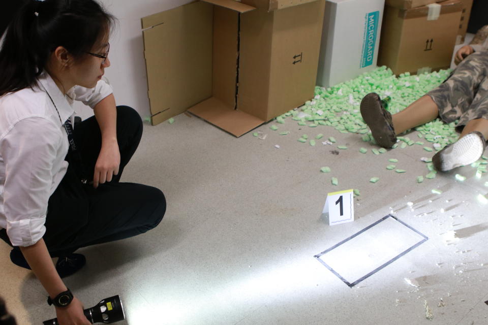 A crime scene specialist ‘examines’ evidence at a mock crime scene at the Singapore Police Force’s CID Forensic Conference 2017. Photo: Hannah Teoh/Yahoo News Singapore