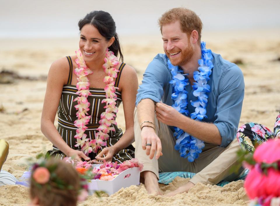 <p>Meghan and Harry sit with a group of children on Bondi beach in Sydney, Australia. </p>