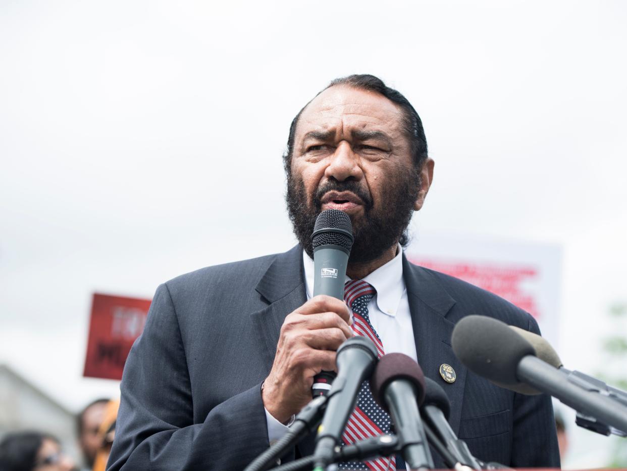 Congressman Al Green wearing a suit and speaking into a microphone