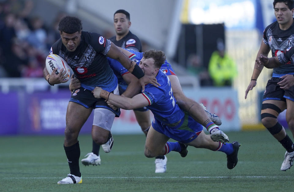 Fiji's Taniela Sadrugu is tackled by Italy's Jack Colovatti during the Rugby League World Cup group B match at Kingston Park, Newcastle upon Tyne, England, Saturday Oct. 22, 2022. (Owen Humphreys/PA via AP)