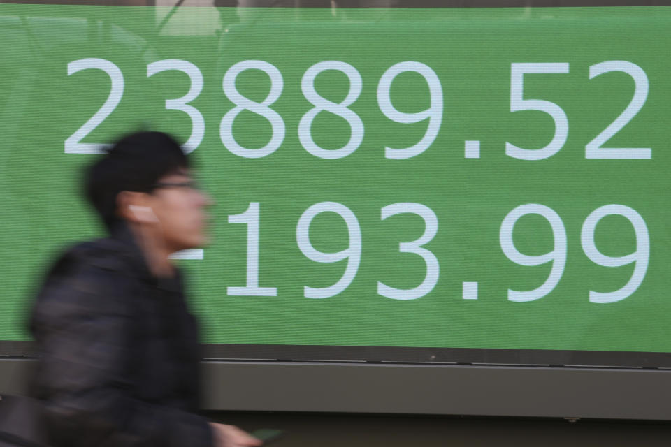 A man walks by an electronic stock board of a securities firm in Tokyo, Tuesday, Jan. 21, 2020. Asian stock markets have tumbled as concern about the impact of a Chinese disease outbreak on tourism and regional economies grows. (AP Photo/Koji Sasahara)