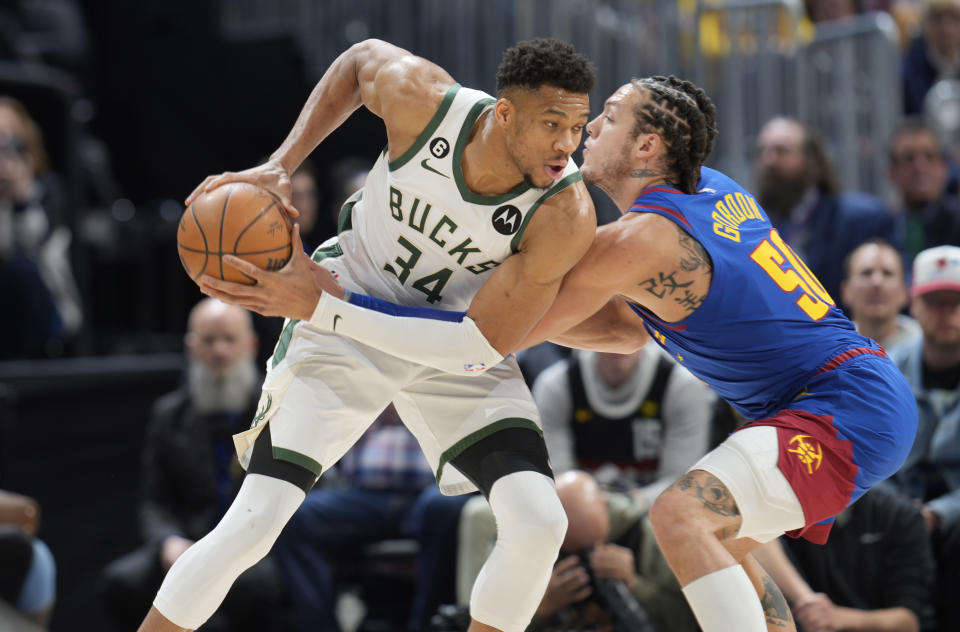 Milwaukee Bucks forward Giannis Antetokounmpo, left, looks to drive to the rim as Denver Nuggets forward Aaron Gordon defends in the first half of an NBA basketball game Saturday, March 25, 2023, in downtown Denver. (AP Photo/David Zalubowski)