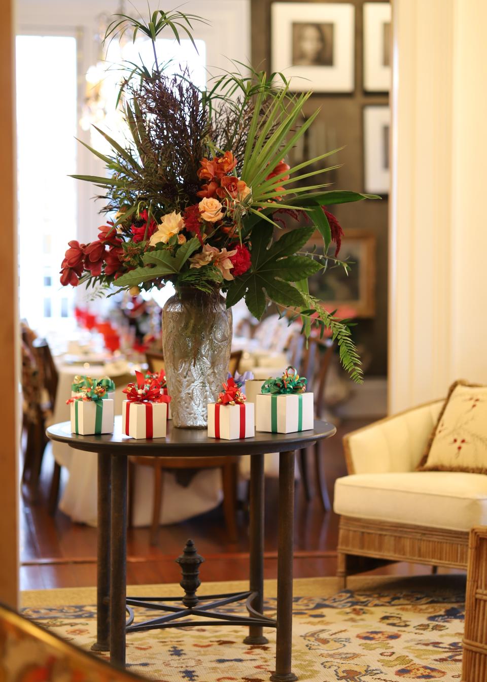 This photo provided by interior designer Elizabeth Stuart shows a side table decoration she created in a home in Charleston, SC. Dining room decorating and centerpieces used during the winter holidays can go beyond pine boughs and holly to incorporate foliage from the region of the country where you live _ including palm fronds _ as seen in this side table decoration created by the South Carolina-based designer. (Travis Drew/Elizabeth Stuart via AP)