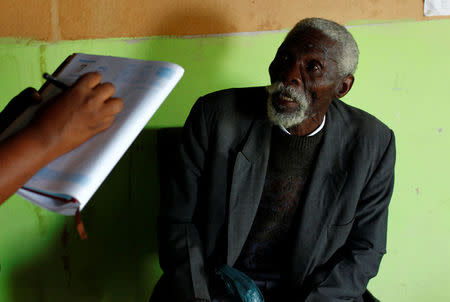Former gold miner Senzele Silewise, 81, talks to paralegals in Bizana in South Africa's impoverished Eastern Cape province March 7, 2012. Silewise worked underground in the country's gold mines for 44 years before being diagnosed with silicosis. REUTERS/Mike Hutchings/File Photo
