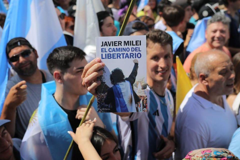 Un joven con el libro de Milei