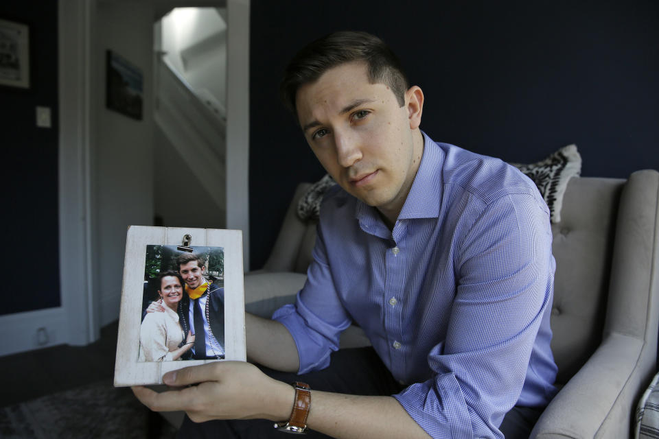 Dane Shikman holds a photograph showing him with his mother, Elizabeth Gaunt, at his home in San Francisco on Friday, April 19, 2019. Gaunt, a former social worker with a history of mental health and substance abuse problems, killed herself in 2015 in the Lake County Jail in northern California. Her son's wrongful death lawsuit resulted in a $2 million settlement. Changes also were made at the jail. (AP Photo/Eric Risberg)