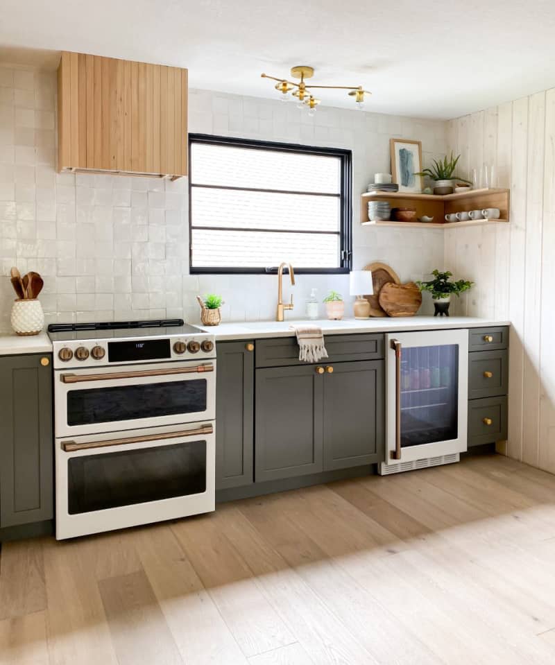 kitchenette after renovation light wood floors dark green cabinets