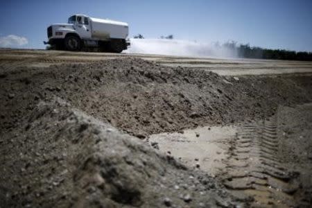 Trucks work on constructing a reservoir on Gless Ranch in Kern County, California, United States July 23, 2015. REUTERS/Lucy Nicholson