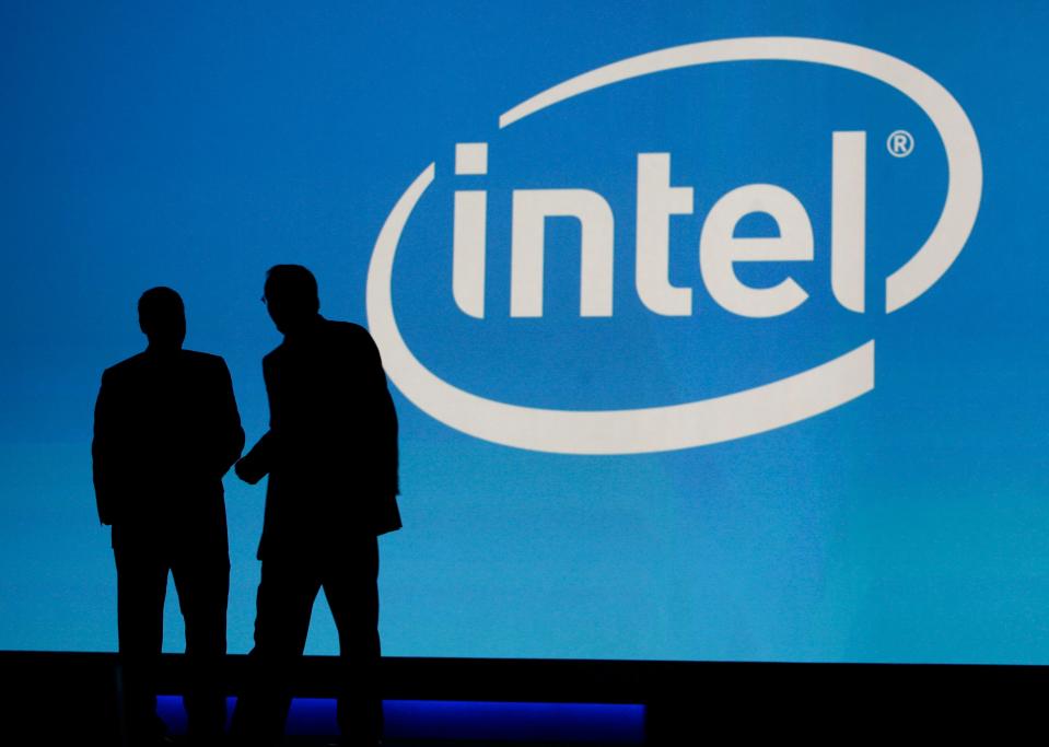 In this 2010 file photo, people are silhouetted in front of the Intel sign at the International Consumer Electronics Show (CES) in Las Vegas.