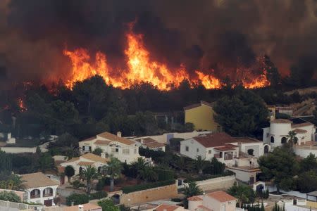 Flames of a wildfire engulf a hillside next to houses in Benitatxell near Alicante, Spain September 5, 2016. REUTERS/Heino Kalis