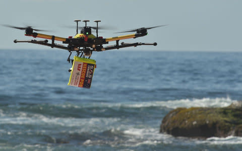 A shark-spotting drone with a safety flotation device attached underneath flying over Bilgola beach north of Sydney. - Credit:  PETER PARKS/ AFP