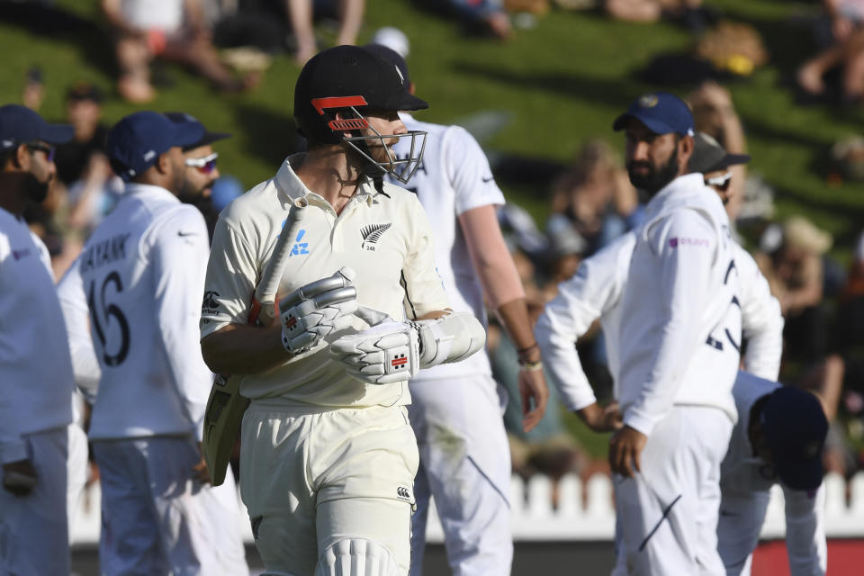 New Zealand's Kane Williamson looks back as the Indian team celebrates after India's Mohammed Shami had dismissed him for 89 during the first cricket test between India and New Zealand at the Basin Reserve in Wellington, New Zealand, Saturday, Feb. 22, 2020. (AP Photo/Ross Setford)