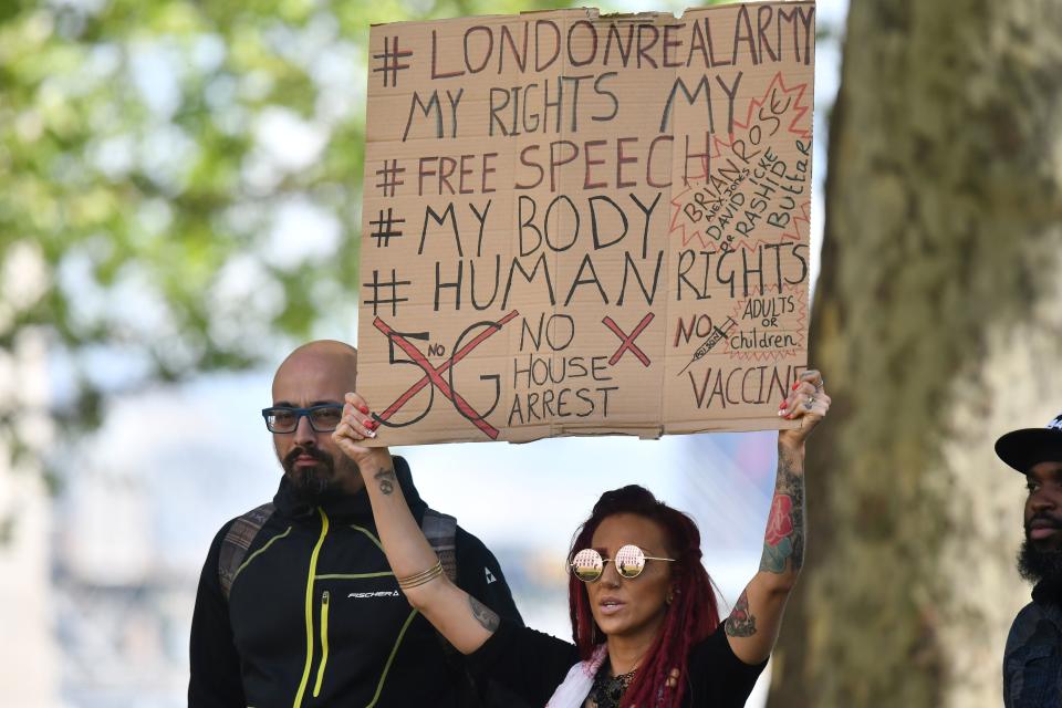 Una manifestante sostiene una pancarta en el exterior de New Scotland Yard en Victoria, Londres, el 2 de mayo de 2020, donde un pequeño grupo se reunió para protestar contra el confinamiento nacional con el objetivo de aplanar la curva de propagación del coronavirus en Reino Unido (Justin Tallis / AFP a través de Getty Images).