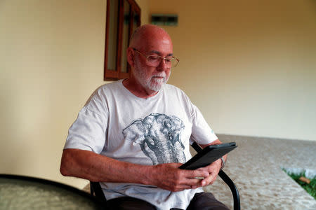 Bryan Walker a retiree from England reads outside his room while staying at the Care Resort in Chiang Mai, Thailand April 5, 2018. Picture taken April 5, 2018. REUTERS/Jorge Silva