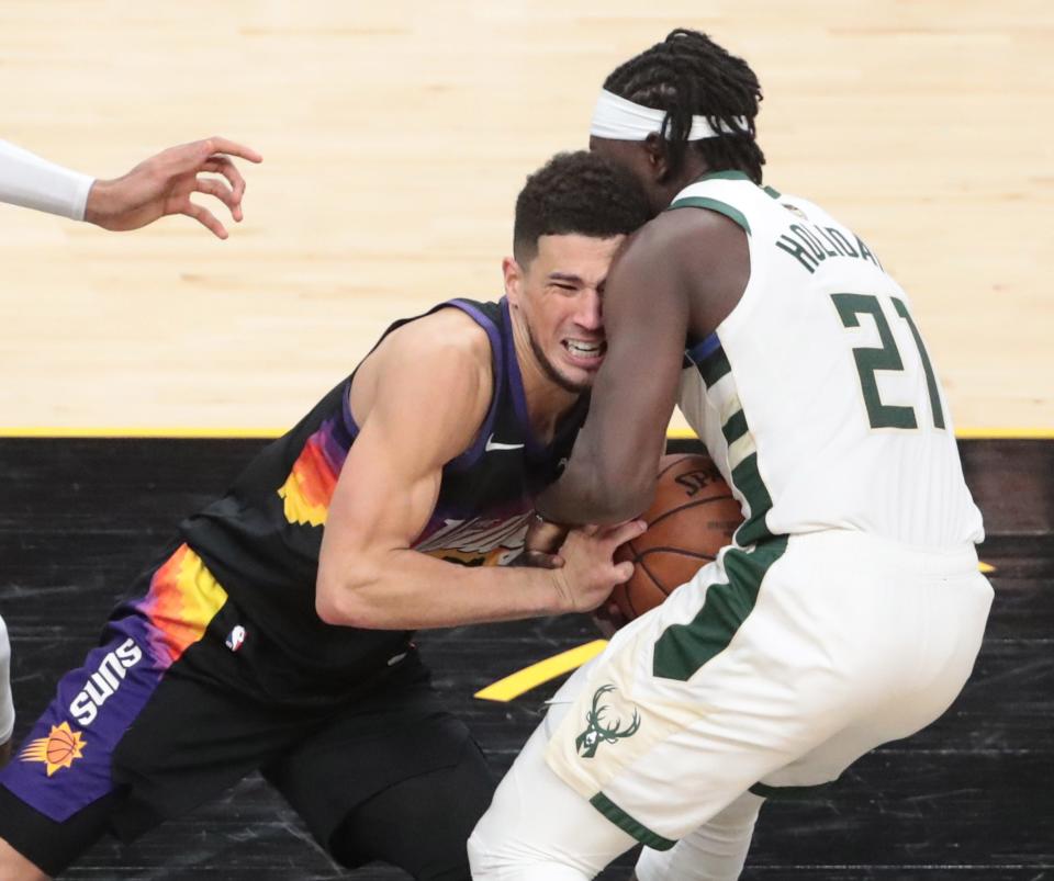 Phoenix Suns guard Devin Booker (1) has the ball stolen by Milwaukee Bucks guard Jrue Holiday (21) in the final seconds during Game 5 of the NBA Finals at Footprint Center July 17, 2021.