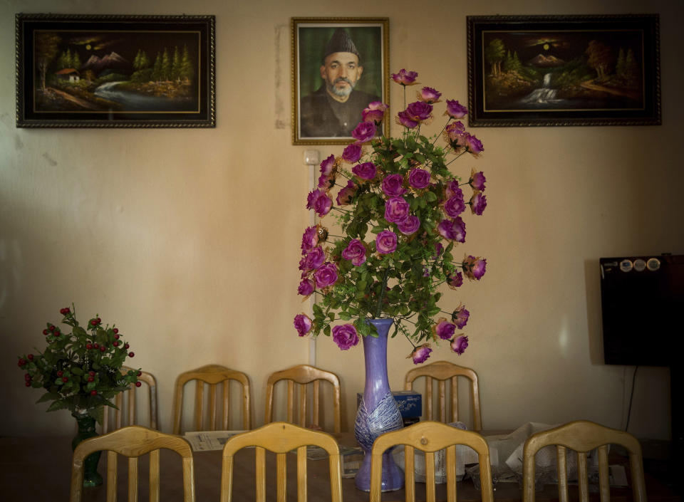 FILE - A picture of Afghan President Hamid Karzai hangs on a wall in the main room of the district municipality in eastern Kabul on Saturday, March 29, 2014, ahead of the April 5, 2014 to choose a new president. Associated Press photographer Anja Niedringhaus was best known as a conflict photographer. Her work helped define the wars in Iraq, Afghanistan, and Libya. (AP Photo/Anja Niedringhaus, File)