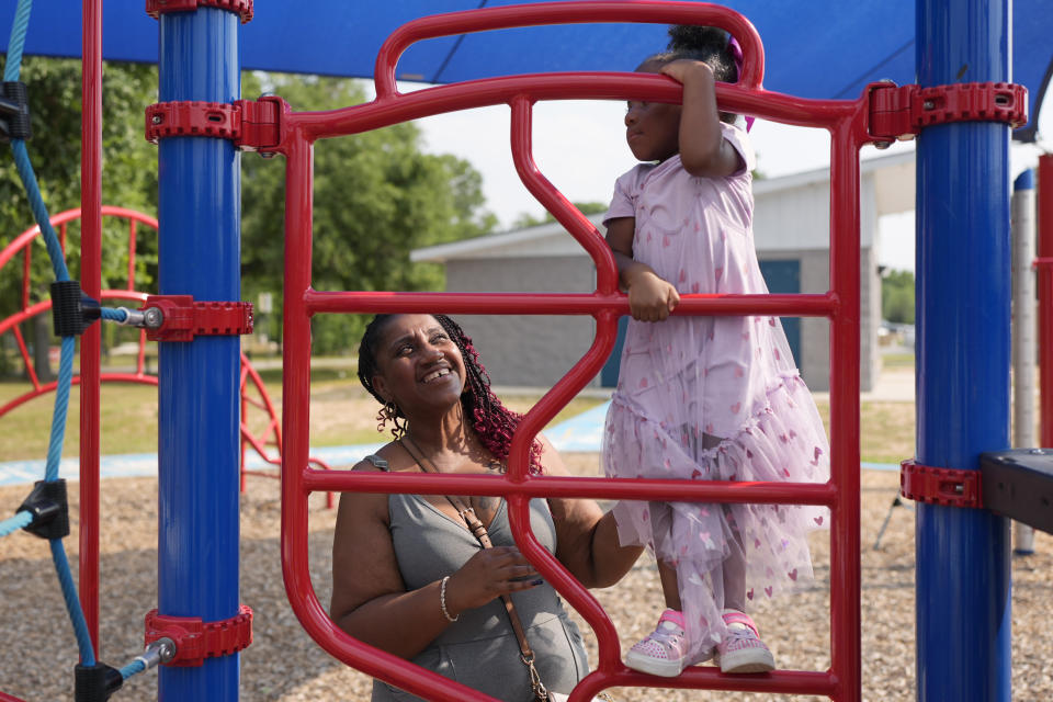 Tamika Davis, right, spends time with her daughter, Shanara, 3, at MLK Park in San Antonio, Thursday, May 30, 2024. Davis said friends and family watched her kids for most of her doctor visits during treatment last year for colon cancer. But she couldn't afford additional childcare, and she didn't know where to look for assistance. (AP Photo/Eric Gay)