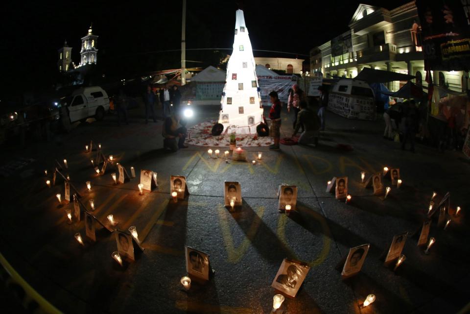 Pictures of the 43 missing trainee teachers from Ayotzinapa Teacher Training College Raul Isidro Burgos are seen in front of a Christmas tree placed by members of the CETEG in the downtown Chilpancingo, Guerrero