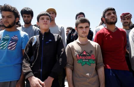 Islamic State prisoners, who were pardoned by a council that is expected to govern Raqqa once the group is dislodged from the Syrian city, stand in Ain Issa village, north of Raqqa, Syria June 24, 2017. REUTERS/Goran Tomasevic